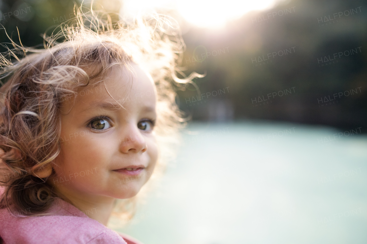 A close-up portrait of small girl standing in nature. Copy space.