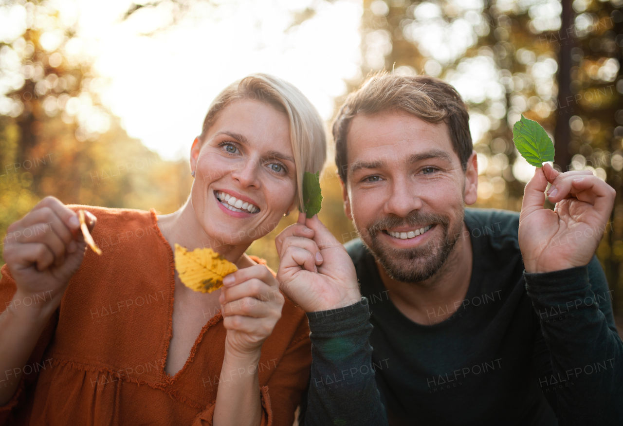 Close-up of young couple in love on a walk in autumn forest, having fun.