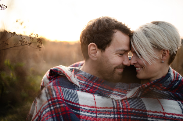 Portrait of young couple in love on a walk in autumn nature, hugging.