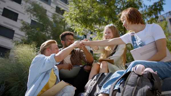 A group of students sitting on staircase, celebrating together.