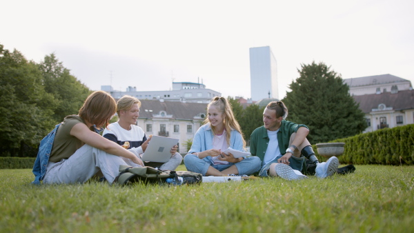 A group of students sitting in park, talking about school project, leg prosthetic concept.