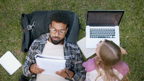 Top view of young student couple in park, talking and working on school project.