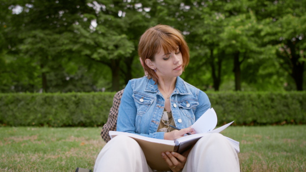 Young student couple sitting in park, working on school project, tourette syndrome concept.