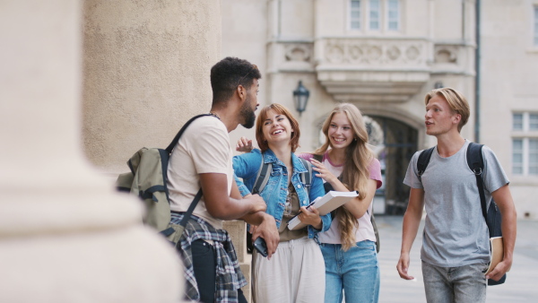 A group of students meeting in front of the university building.