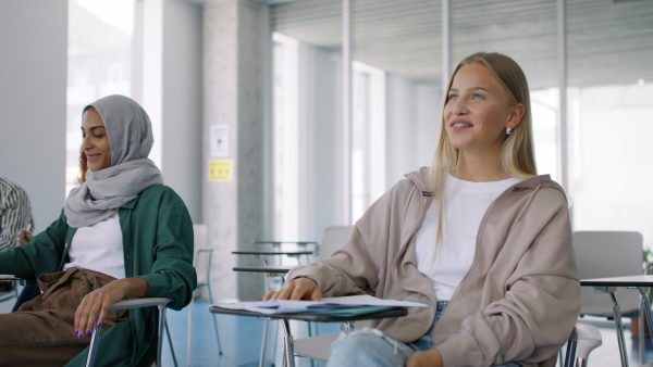 University students with a teacher studying indoors, lesson in classroom.