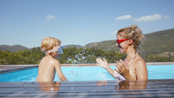 A little boy having fun with his mother in the pool.