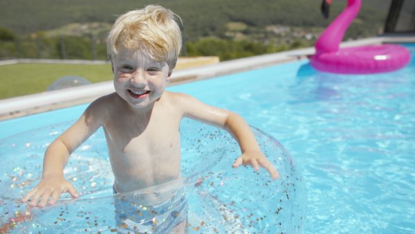 A little boy having fun in inflatable ring in the pool.