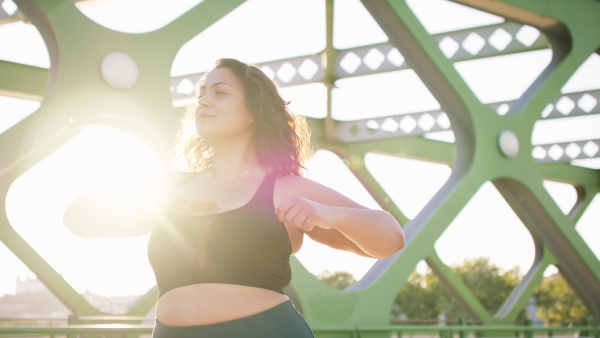 A close up of young overweight woman exercising outdoors in bridge.