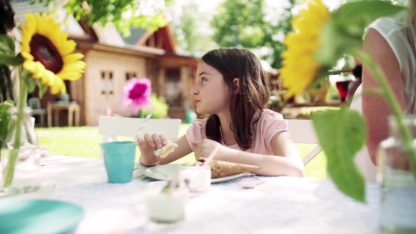 Children eating icecream on birthday party outdoors in garden in summer. Slow motion.