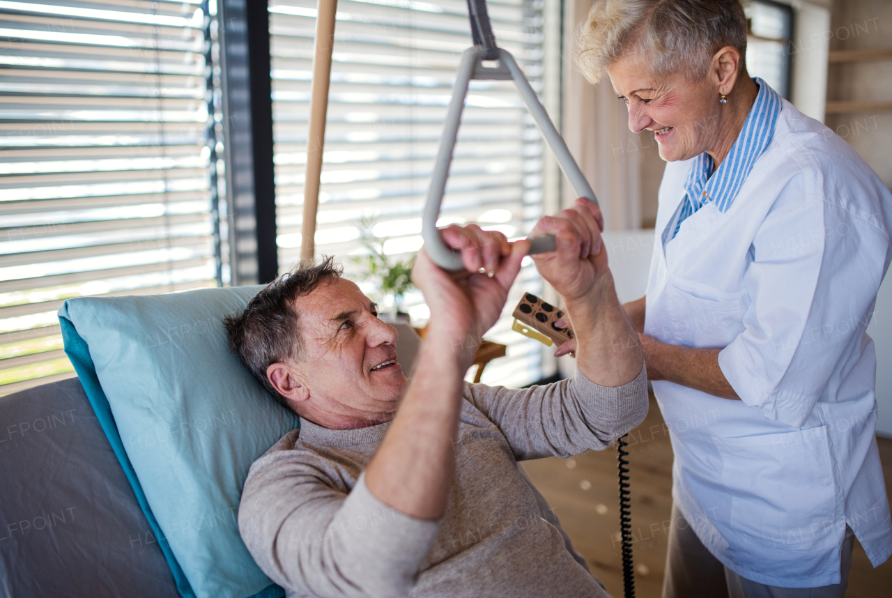 A healthcare worker helping paralysed senior patient in hospital.