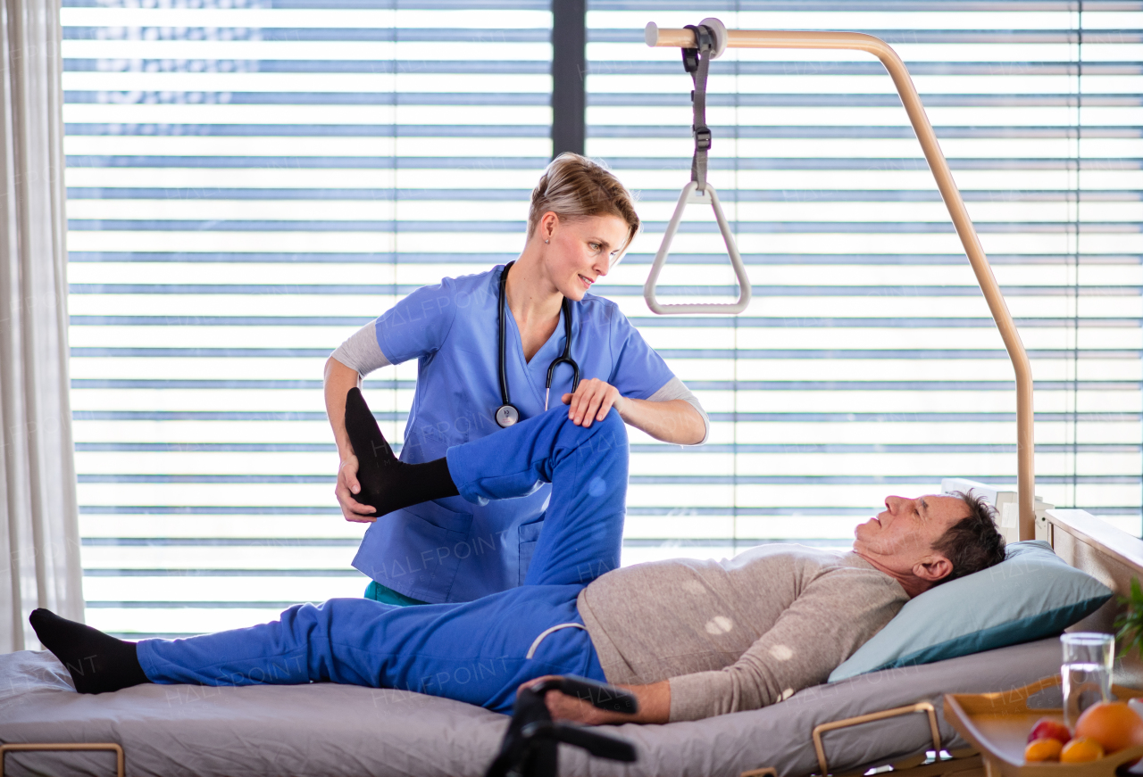 A healthcare worker and senior patient in hospital, physiotherapy concept.