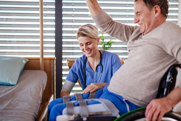 A healthcare worker and senior patient in wheelchair, physiotherapy concept.