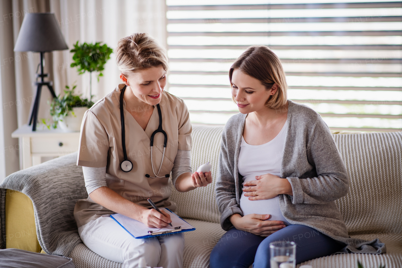 A healthcare worker examining pregnant woman indoors at home, checking sugar level.