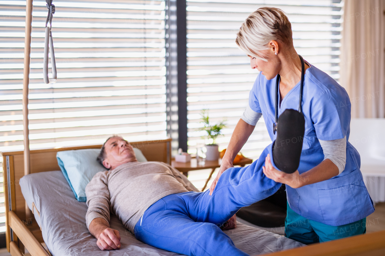 A healthcare worker and senior patient in hospital, physiotherapy concept.