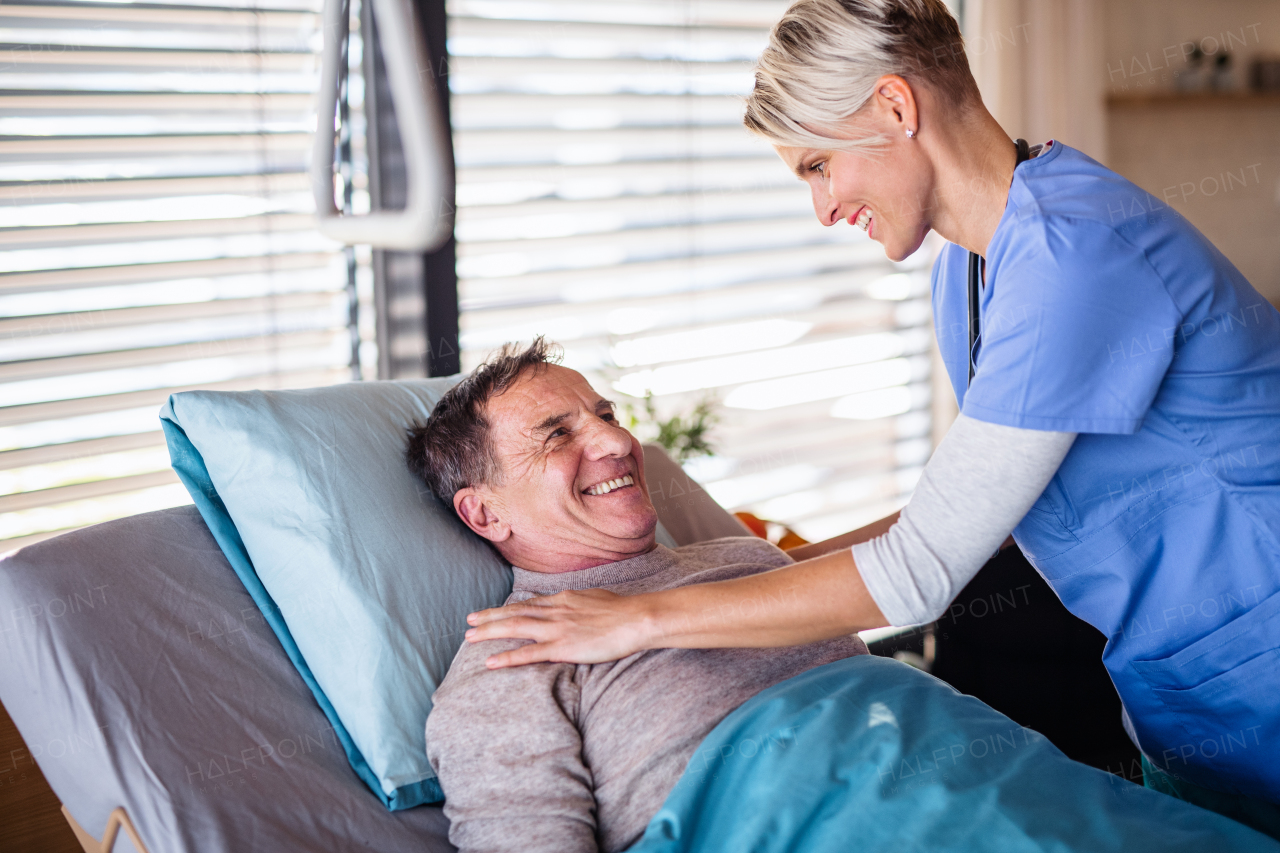 A friendly healthcare worker and senior patient in hospital, talking.