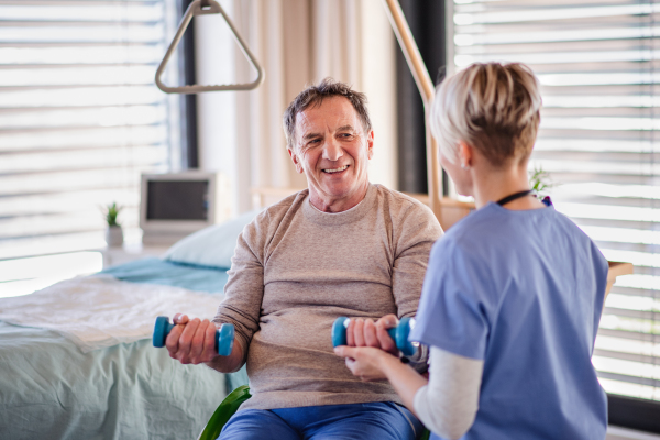 A healthcare worker and senior patient in hospital, doing exercise.