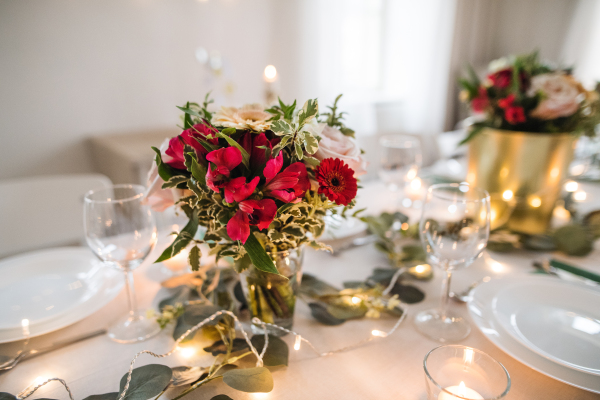 A table set for a meal indoors in a room on a party, a wedding or family celebration.