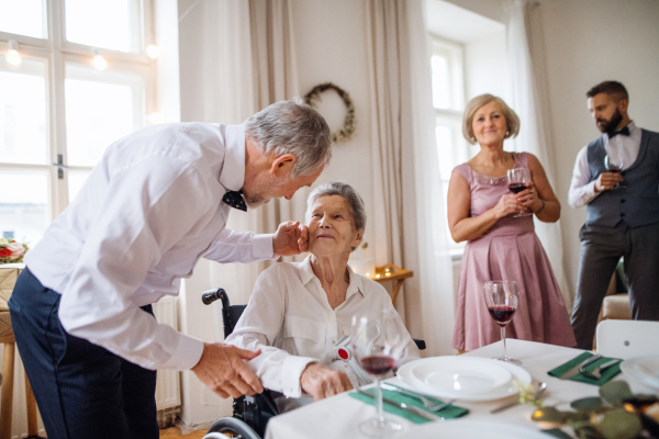 An elderly grandmother in a wheelchair celebrating birthday with family, a party concept.