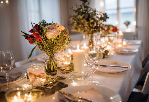 A table set for a meal indoors in a room on a party, a wedding or family celebration.