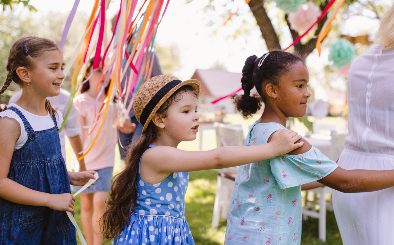 Small children walking outdoors in garden in summer, playing. A celebration concept.