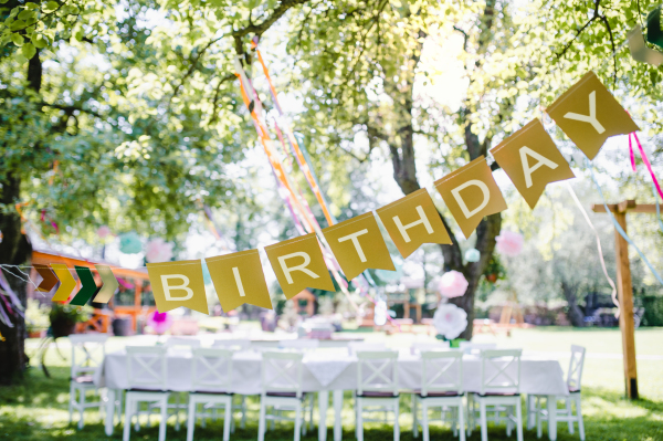 A table set for kids birthday party outdoors in garden in summer, celebration concept.