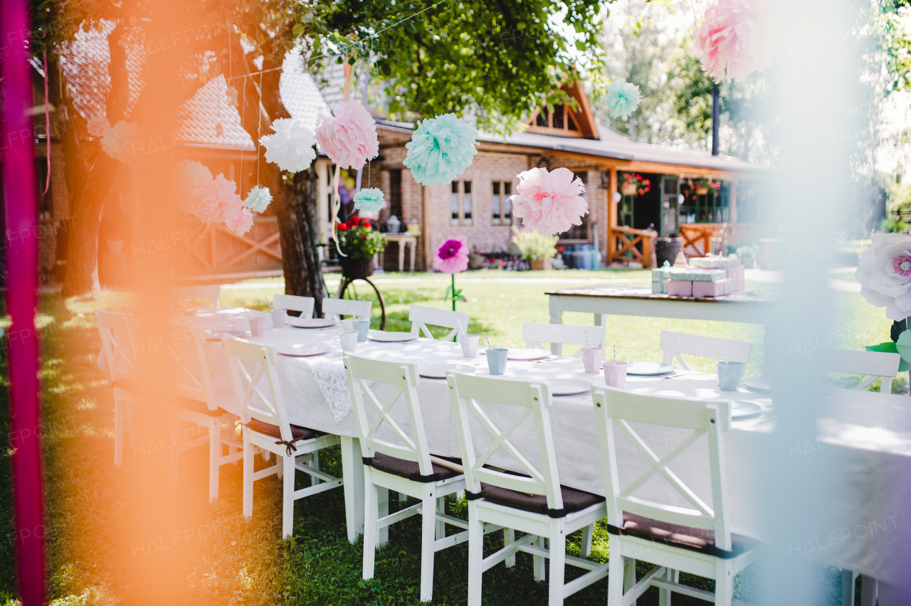 A table set for kids birthday party outdoors in garden in summer, celebration concept.