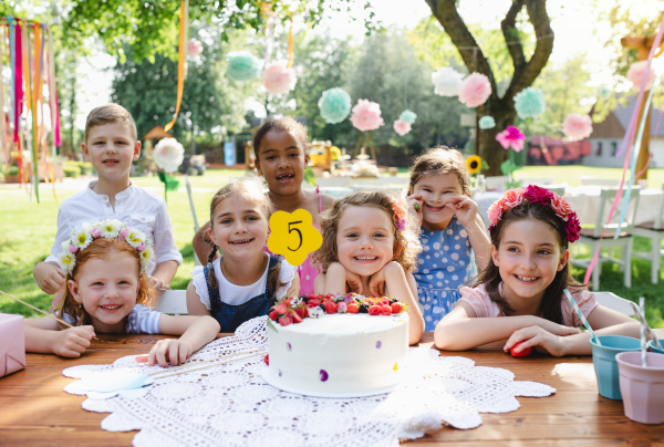 Kids birthday party outdoors in garden in summer, a celebration concept.