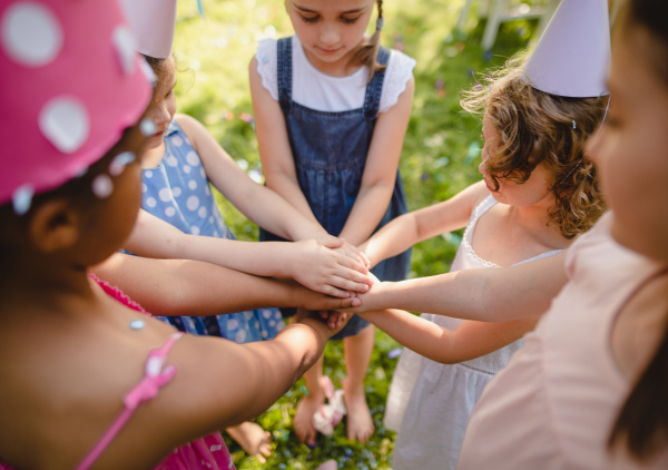 Children playing outdoors on birthday party in garden in summer, celebration concept.