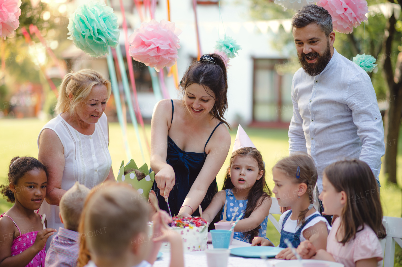 Happy kids birthday party outdoors in garden in summer, celebration concept.