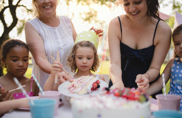 Kids birthday party outdoors in garden in summer, a celebration concept.