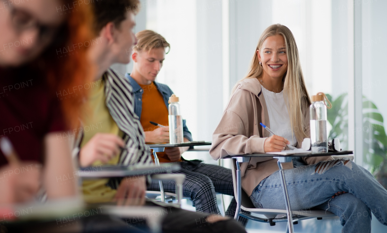 A portrait of group of university students sitting in classroom indoors, studying