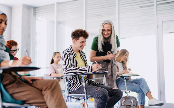 University students with a teacher studying indoors, lesson in classroom.