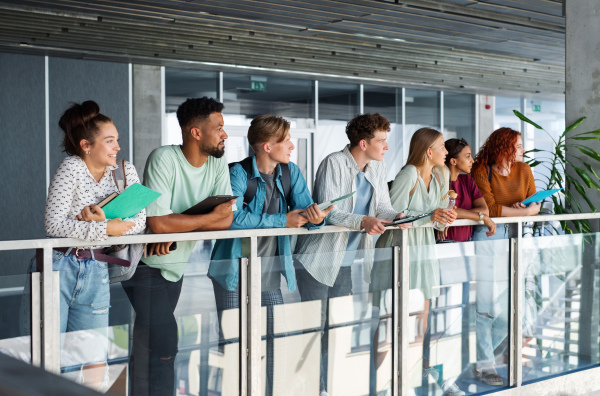 A group of university students standing indoors, back to school concept.