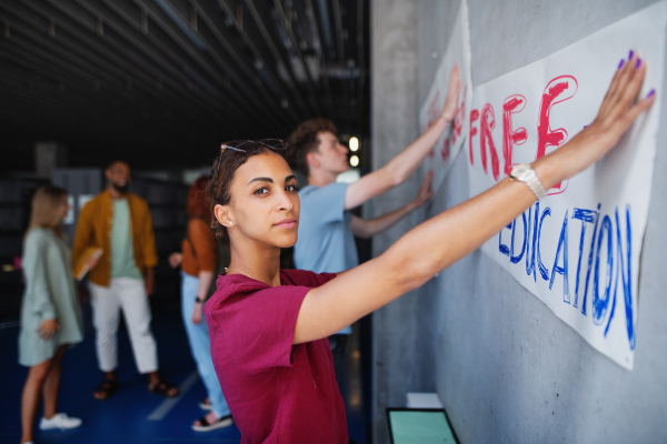 University students activists protesting indoors at school, fighting for free education concept.