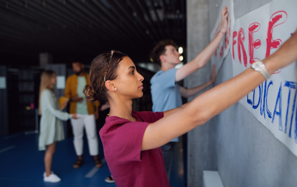 University students activists protesting indoors at school, fighting for free education concept.