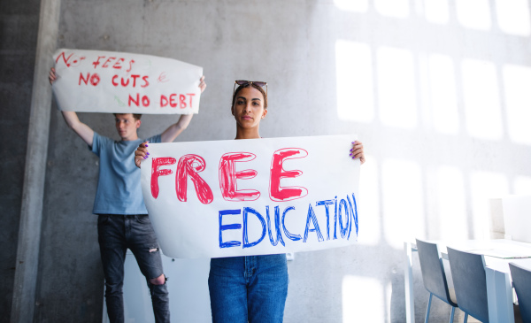 University students activists protesting indoors at school, fighting for free education concept.