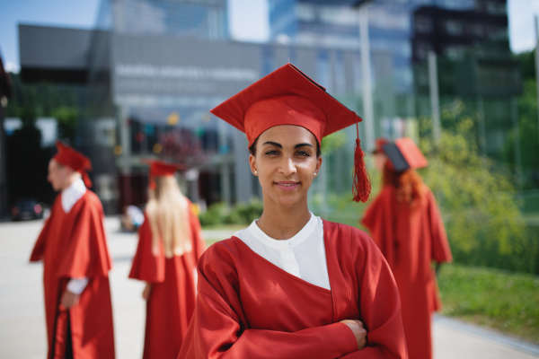 A portrait of cheerful university student looking at camera, graduation concept.