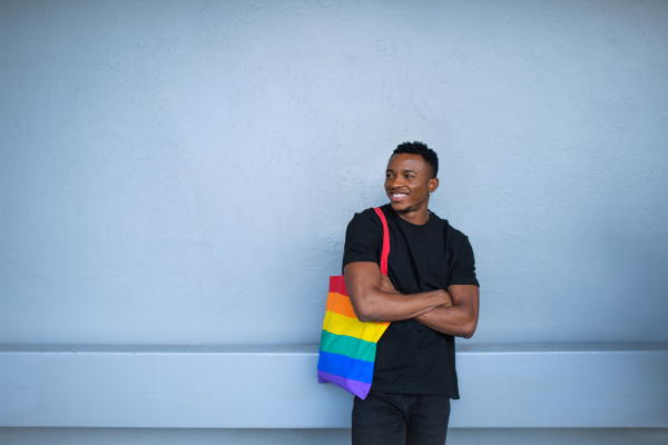 Cheerful young black man standing against white wall background, black lives matter concept.