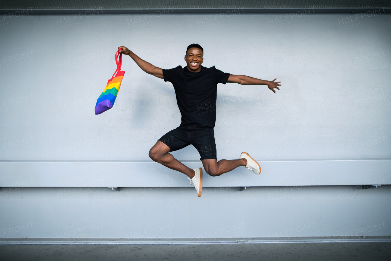 Cheerful young black man jumping against white wall background, black lives matter concept.