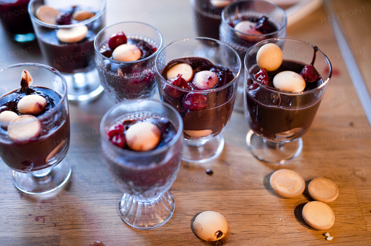 Top view of desserts in glasses on wooden table, close-up.