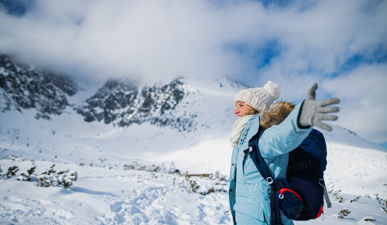 Side view portrait of happy smiling woman standing in snowy winter nature.