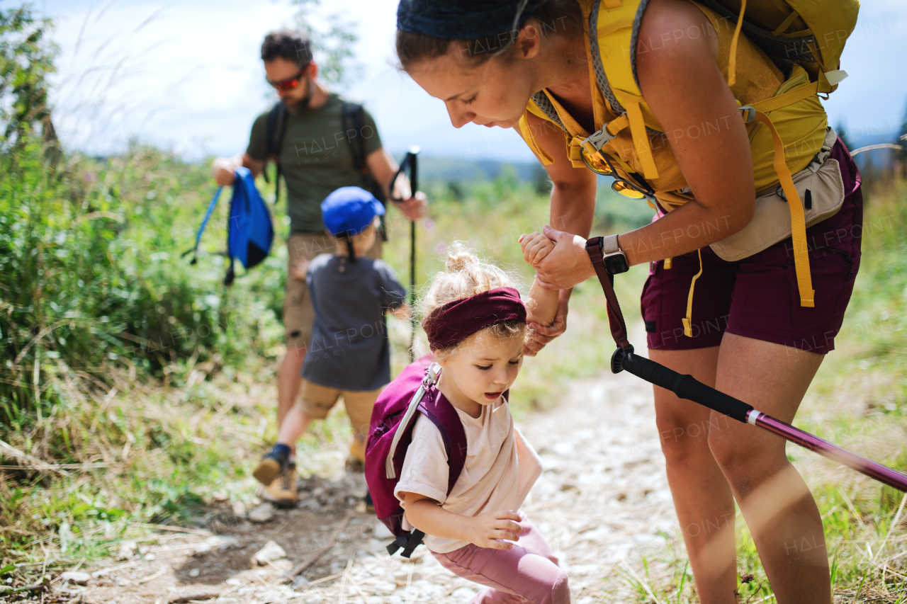 Portrait of family with upset small children hiking outdoors in summer nature.