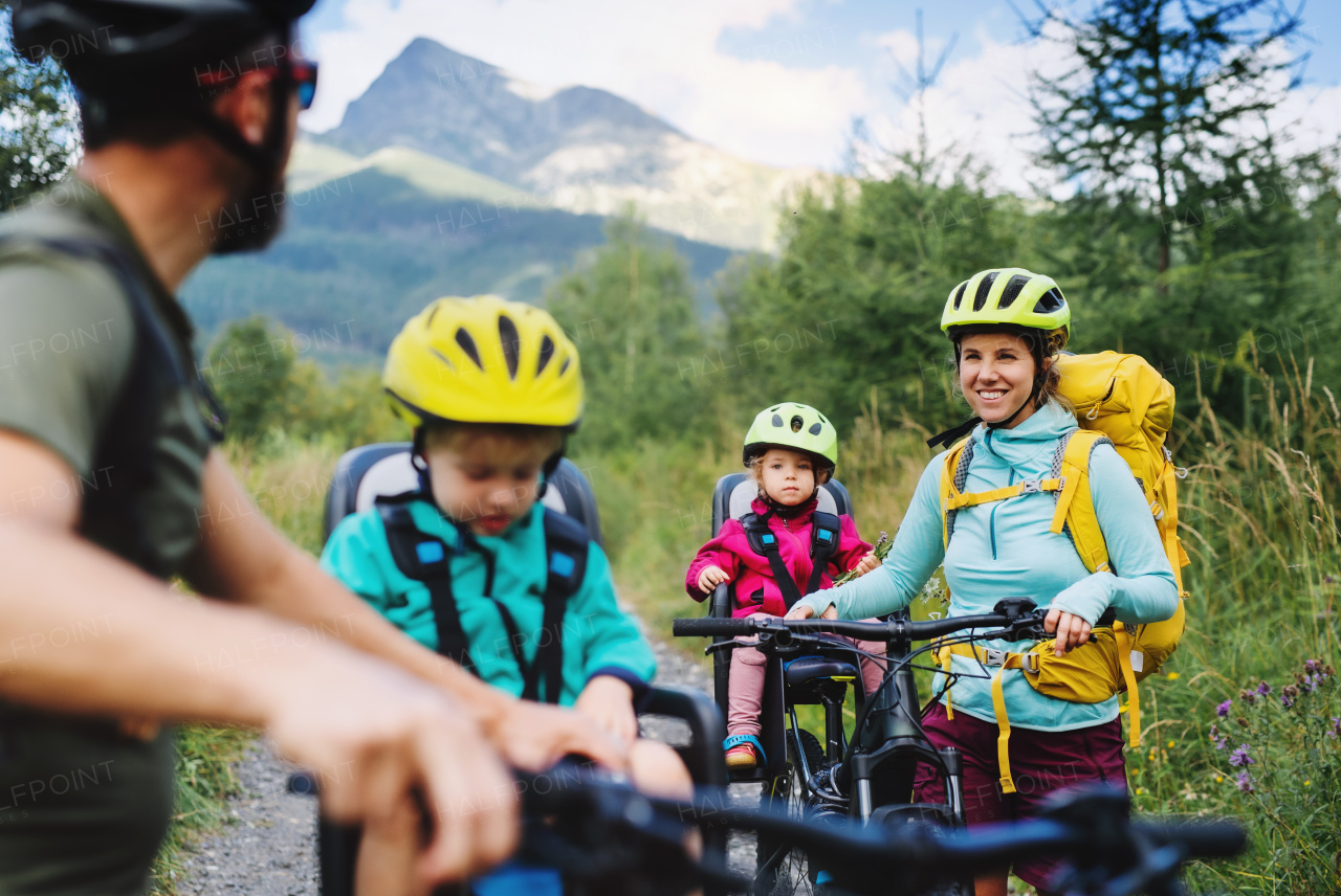 Happy family with small children cycling outdoors in summer nature, Tatra mountains Slovakia.