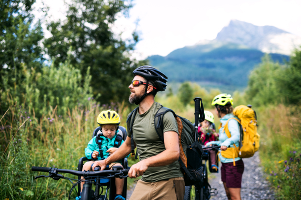 Happy family with small children with bicycles outdoors in summer nature, High Tatras in Slovakia.