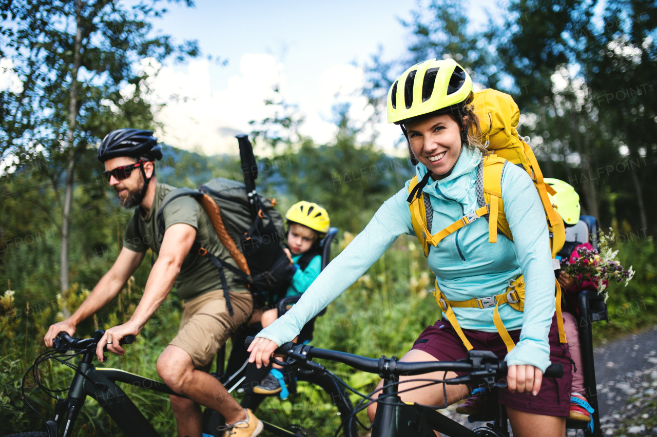 Happy family with small children cycling outdoors in summer nature, High Tatras in Slovakia.