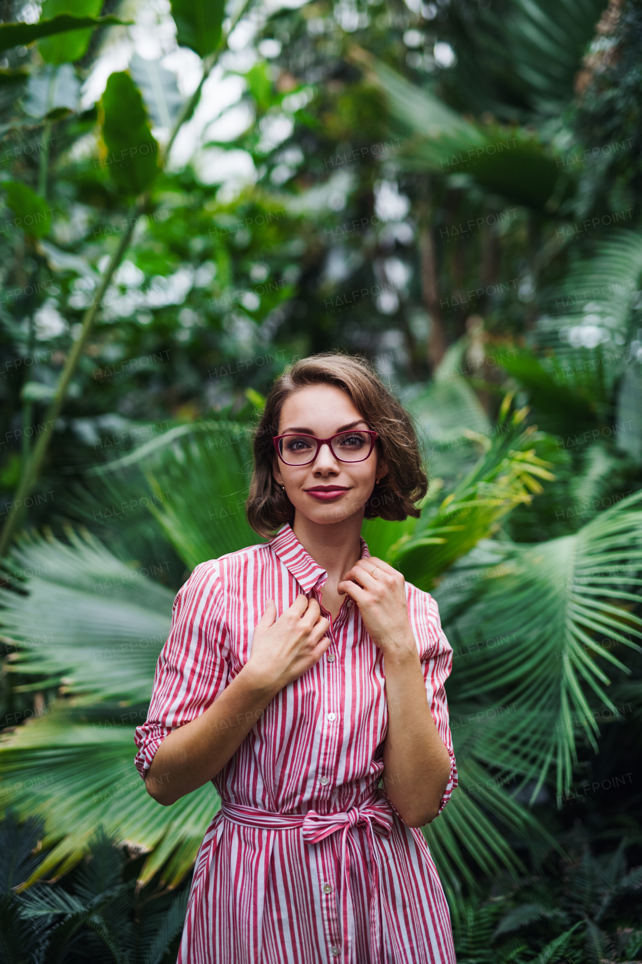 A young woman standing in botanical garden. Copy space.