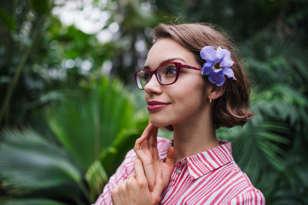 A young woman standing in botanical garden. Copy space.