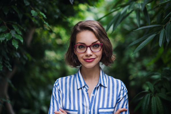 A young woman standing in botanical garden. Copy space.