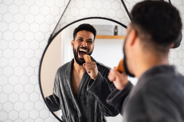 A young man having fun indoors at home, morning or evening routine concept.