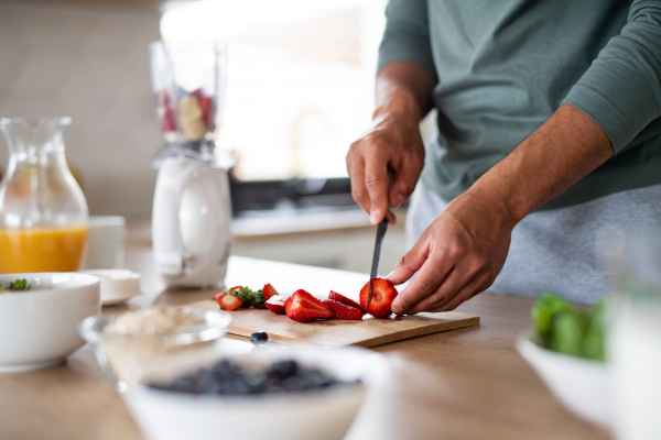 Midsection of unrecognizable man preparing smoothie indoors at home, healthy diet concept.